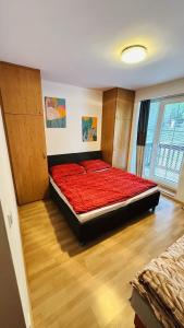 a bedroom with a bed with a red comforter at Apartmán Špindl 101čka Dalibor II in Špindlerův Mlýn