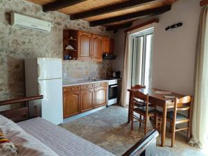 a kitchen with a table and a white refrigerator at The Old barrel houses in Kythira