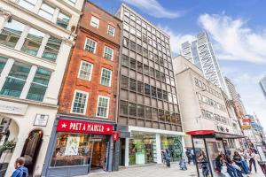 a group of buildings on a city street with people at GORGEOUS FlatD Central London Liverpool St Station in London