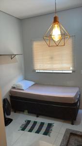 un letto in una camera con finestra e lampada di 104 FLATS MAGGUINE Interlagos a Rio Verde