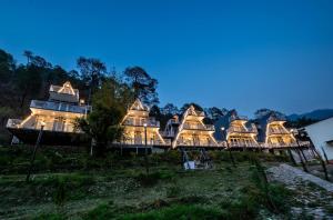 a large house on a hill at night at Kainchi Retreat near Kainchi Dham in Rāmgarh +28 photos