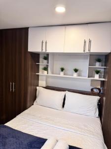 a bedroom with a bed with white cabinets and potted plants at 2211 Despierta en poblado Medellín - Vista panorámica in Medellín