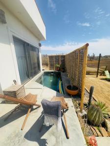 un patio con 2 sedie e una piscina di Casa Pakal-Cozy Cottage Near Cerritos Beach a San Carlos