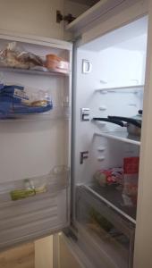 a refrigerator with its door open with food inside at GORGEOUS FlatD Central London Liverpool St Station in London