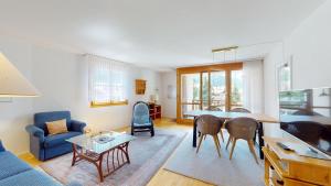 a living room with a blue couch and a table at Flurina 43 in Silvaplana
