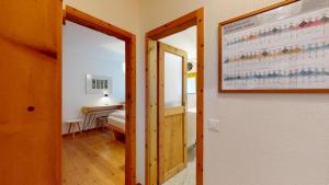 a hallway with a door and a room with a bed at Alvra 1 in Celerina
