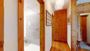a hallway with a shower and a wooden door at Alvra 1 in Celerina