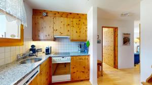 a kitchen with wooden cabinets and a sink at Flurina 43 in Silvaplana +16 photos