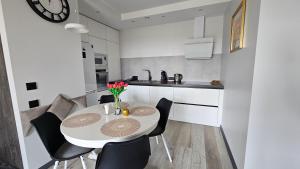 a small white kitchen with a table and chairs at AA Apartments OldTown in Klaipėda