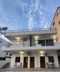 a white house with a balcony and stairs at Hotel Barjami in Sarandë