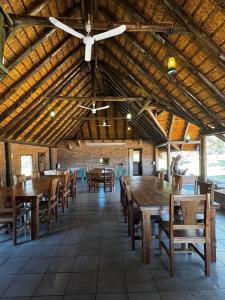 a large dining room with wooden tables and chairs at Welgedacht Lodge in Cullinan