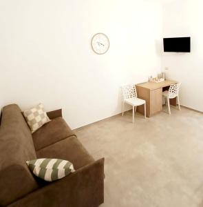 a living room with a couch and a desk at B&B Petrae House in Ostuni