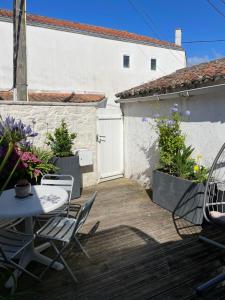 a patio with a table and chairs and a building at La traboule in La Tranche-sur-Mer