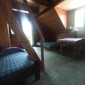 a attic room with a bed and a table at Puszcza Romincka in Galwiecie +24 photos