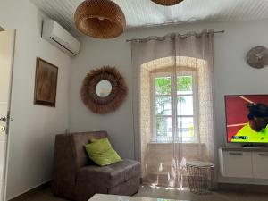 a living room with a television and a chair and a window at Zanzibar in Savina