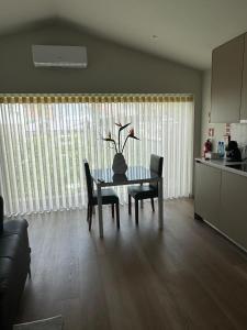 a living room with a table and chairs and a kitchen at Casa do Pitoco in Belinho +10 photos