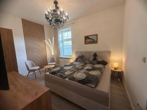 a bedroom with a large bed and a chandelier at Haus Burmeister in Sassnitz