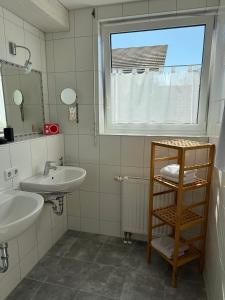a bathroom with two sinks and a window at Ferienwohnungen Günther Hund in Immenstaad am Bodensee