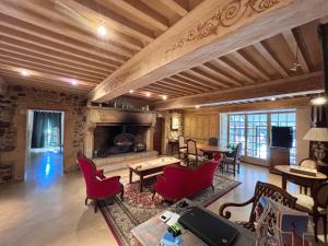 a living room with a fireplace and red chairs at DOMAINE DE LA RESERVE in Coublanc