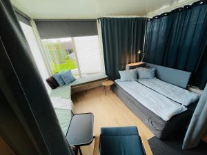 Una pequeña habitación con dos camas y una ventana. en Floien City Apartment -Free parking, en Bergen