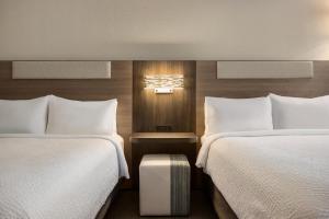 a hotel room with two beds and a table between them at Holiday Inn Express Fort Lauderdale Airport South by IHG in Dania Beach