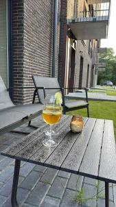 a glass of wine and a piece of bread on a table at Luxury Šarli Apartment Nemirsetos parke in Palanga