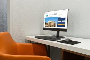 a computer monitor sitting on top of a desk at Holiday Inn Express Fort Lauderdale Airport South by IHG in Dania Beach