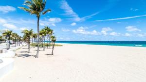 a sandy beach with palm trees and the ocean at Holiday Inn Express Fort Lauderdale Airport South by IHG in Dania Beach