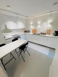 Una cocina con gabinetes blancos y una mesa y sillas. en Floien City Apartment -Free parking, en Bergen