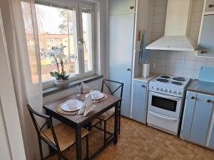 a kitchen with a table with chairs and a stove at Mysiga 21 an in Mariehamn