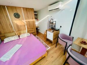 a bedroom with a pink bed and a table at Beus home 2 in Durrës +5 photos