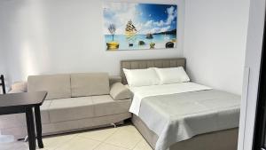 a living room with a couch and a painting on the wall at Bebi Guest House in Sarandë