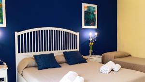 a bedroom with two beds with blue walls at Medoro Piazza Roma Rooms in Milazzo