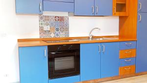a kitchen with blue cabinets and a sink at Medoro Piazza Roma Rooms in Milazzo