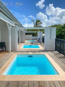 una piscina en una terraza junto a una casa en Bungalow bord de mer, en Le Robert