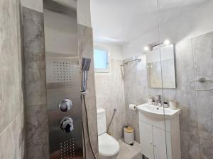 Un baño con ducha, inodoro y lavabo. en Odysseas Apartments, en Marathokampos