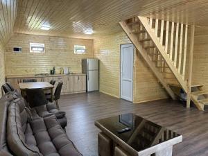 a living room with a staircase and a kitchen at Tuta Cottage near Martvili Canyon in Martvili