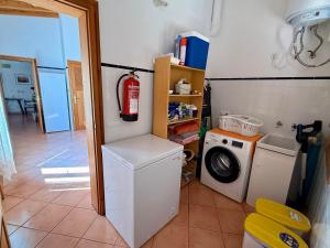 a laundry room with a washing machine and a washer at Casa rural, finca rústica con piscina Cas Padrins de Campos, Mallorca in Campos
