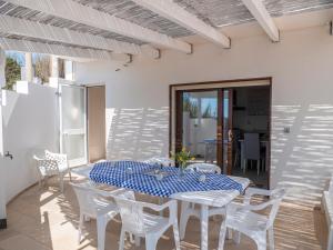 a white dining room with a blue and white table and chairs at Villa Cordella 1 in Marina San Gregorio