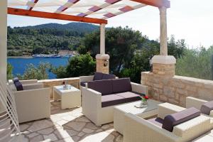 a patio with chairs and tables and a view of the water at Boutique Hotel Villa Telenta in Vela Luka