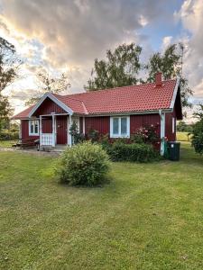 雪平斯维克Röda stugan的院子里有红色屋顶的红色房子