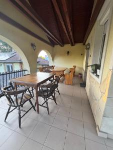 Un patio al aire libre con una mesa y sillas de madera. en Missy House, en Igricetanya