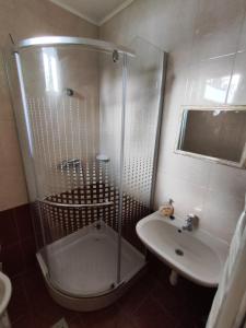 un baño con ducha y lavabo en Missy House, en Igricetanya