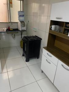 a small kitchen with a stove and white cabinets at Caruaru apartamento in Caruaru