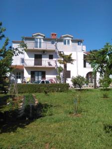 a large white building with a yard in front of it at Apartments Zova in Medulin