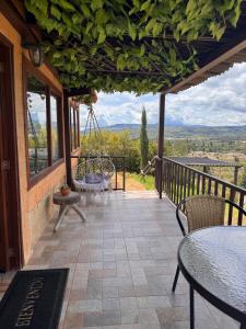 a patio with tables and chairs on a balcony at Glamping El Sol Mirador Jarana Villa de Leyva in Villa de Leyva