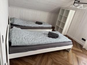 two beds in a room with wooden floors at Sea Spray Nida in Nida