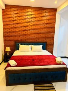 um quarto com uma cama grande com uma parede de tijolos em Unic Residence And Transit Hotel em Katunayaka