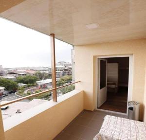 a room with a balcony with a view of a city at Your Hostel in Yerevan