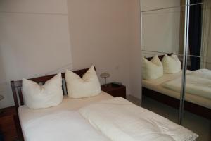 een slaapkamer met 2 bedden met witte kussens en een spiegel bij Ferienwohnung Jagdschloss Bielatal in Bielatal